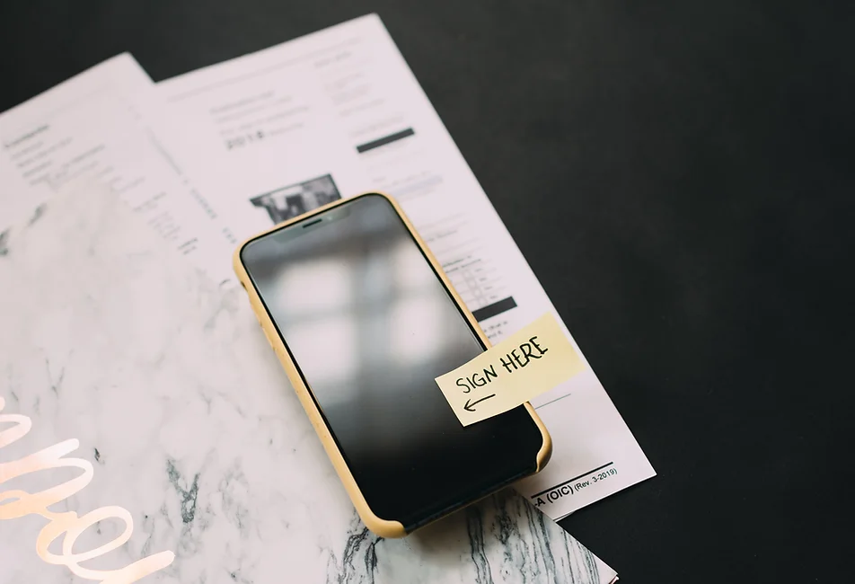 Apple iPhone with a sign here post-it demonstrating digital forms completion at Genuine Orthodontics in Brentwood, TN